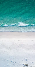 迎着海风踏浪，高清海水拍打沙滩的航拍手机壁纸