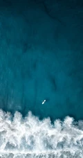 迎着海风踏浪，高清海水拍打沙滩的航拍手机壁纸