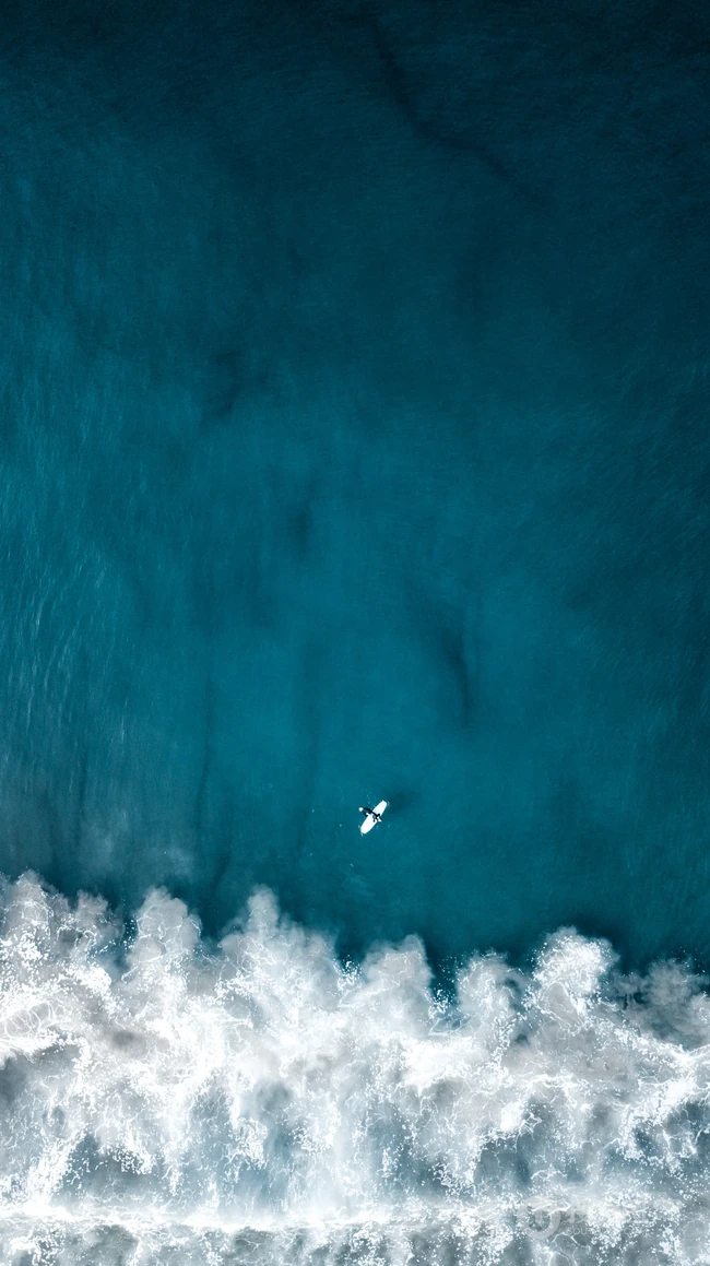 迎着海风踏浪，高清海水拍打沙滩的航拍手机壁纸