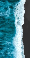 迎着海风踏浪，高清海水拍打沙滩的航拍手机壁纸