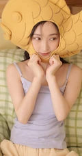 头戴一只鱼抱枕的俏皮可爱萌短裤少女室内写真图片