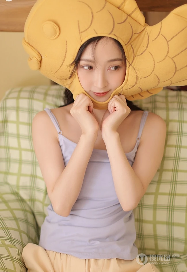 头戴一只鱼抱枕的俏皮可爱萌短裤少女室内写真图片