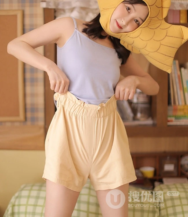 头戴一只鱼抱枕的俏皮可爱萌短裤少女室内写真图片