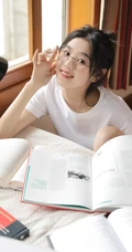 戴眼镜的丸子头少女，边享受水果，边学习唯美清新写真