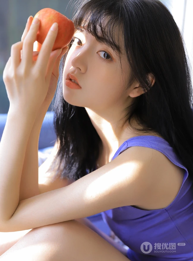 齐刘海少女佳人，手拿苹果，穿着背心短裤室内写真图片
