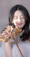 陈昊宇卷发白裙俏皮优雅写真图片，手持干巴向日葵抱膝半蹲
