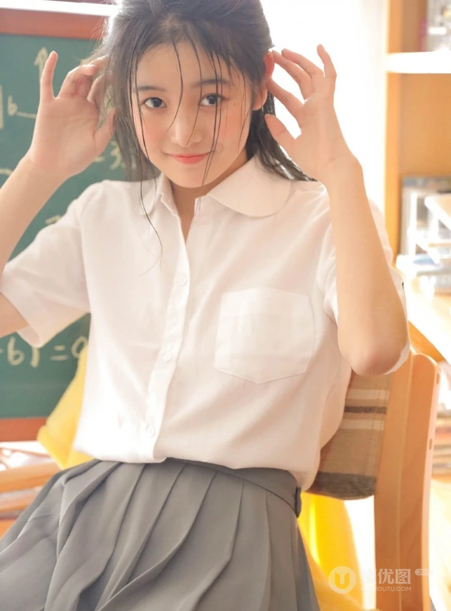 清纯可爱学生妹子白衫灰裙制服短裙装手拿苹果在教室写真图片