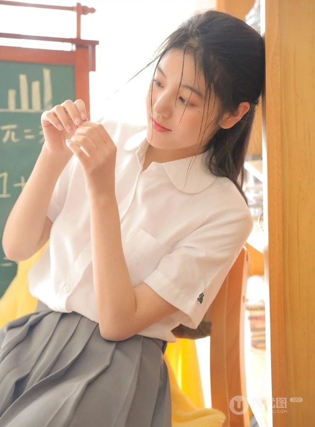 清纯可爱学生妹子白衫灰裙制服短裙装手拿苹果在教室写真图片