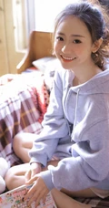 长腿少女卫衣短裤室内写真，丸子头发型，笑容灿烂