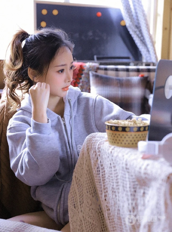 长腿少女卫衣短裤室内写真，丸子头发型，笑容灿烂