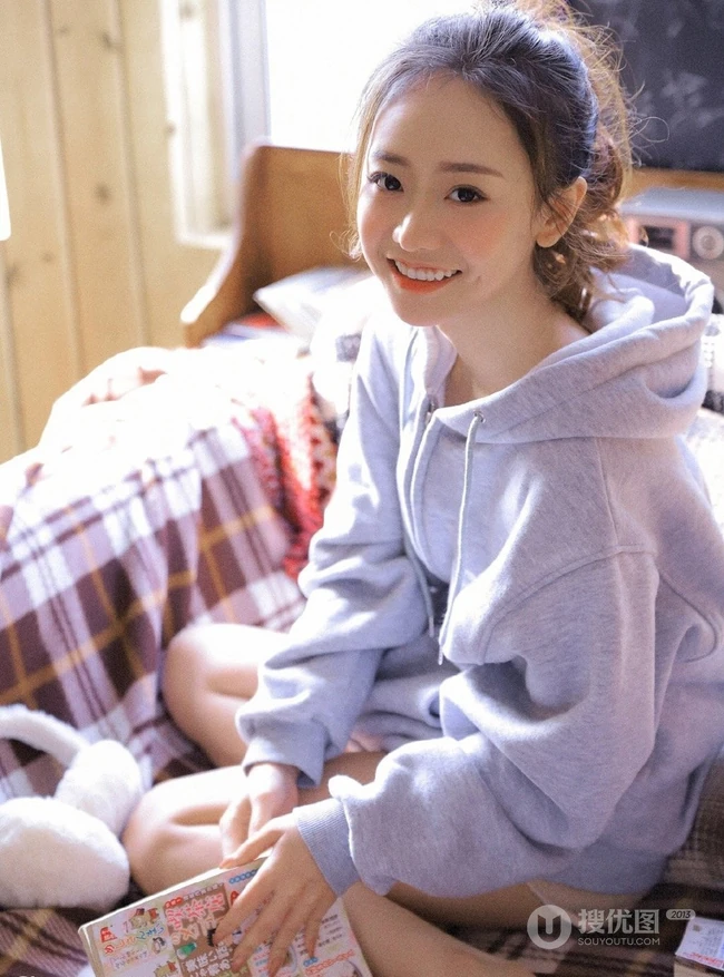 长腿少女卫衣短裤室内写真，丸子头发型，笑容灿烂