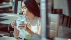 冬季街头，繁华都市的咖啡厅里喝着咖啡的欧美女生高清壁纸