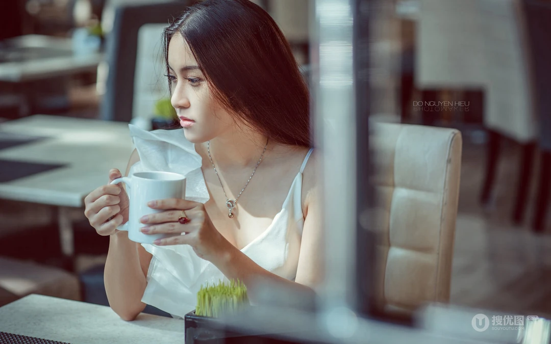 冬季街头，繁华都市的咖啡厅里喝着咖啡的欧美女生高清壁纸
