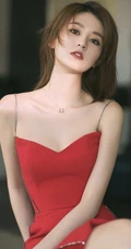 女生乔欣肩带红裙气质出镜，双腿交叉静坐姿态动人