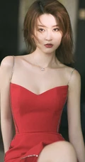 女生乔欣肩带红裙气质出镜，双腿交叉静坐姿态动人