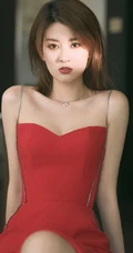 女生乔欣肩带红裙气质出镜，双腿交叉静坐姿态动人