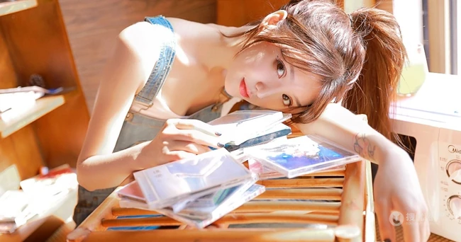 甜美动人马尾辫肩带牛仔裤少女室内晒太阳温暖写真图片