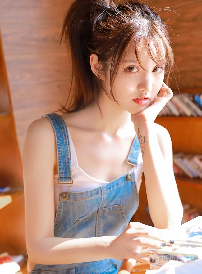 甜美动人马尾辫肩带牛仔裤少女室内晒太阳温暖写真图片