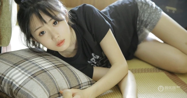 动人小脸丸子头文艺少女黑T银裙室内沙发写真图片