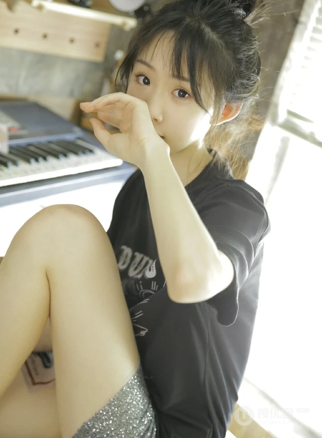 动人小脸丸子头文艺少女黑T银裙室内沙发写真图片