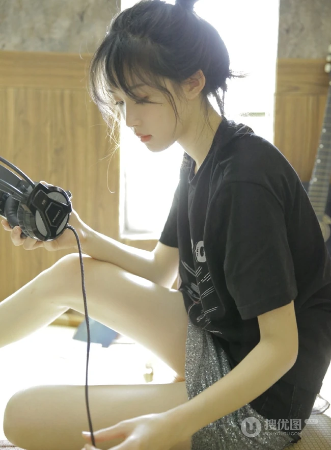 动人小脸丸子头文艺少女黑T银裙室内沙发写真图片
