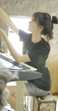 动人小脸丸子头文艺少女黑T银裙室内沙发写真图片
