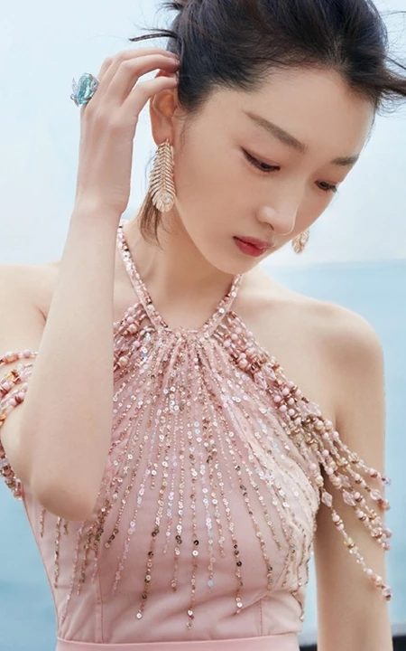 周冬雨不畏严寒，着肩带粉裙现身海边，优雅而动人