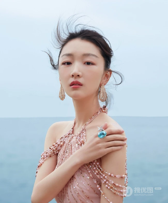 周冬雨不畏严寒，着肩带粉裙现身海边，优雅而动人