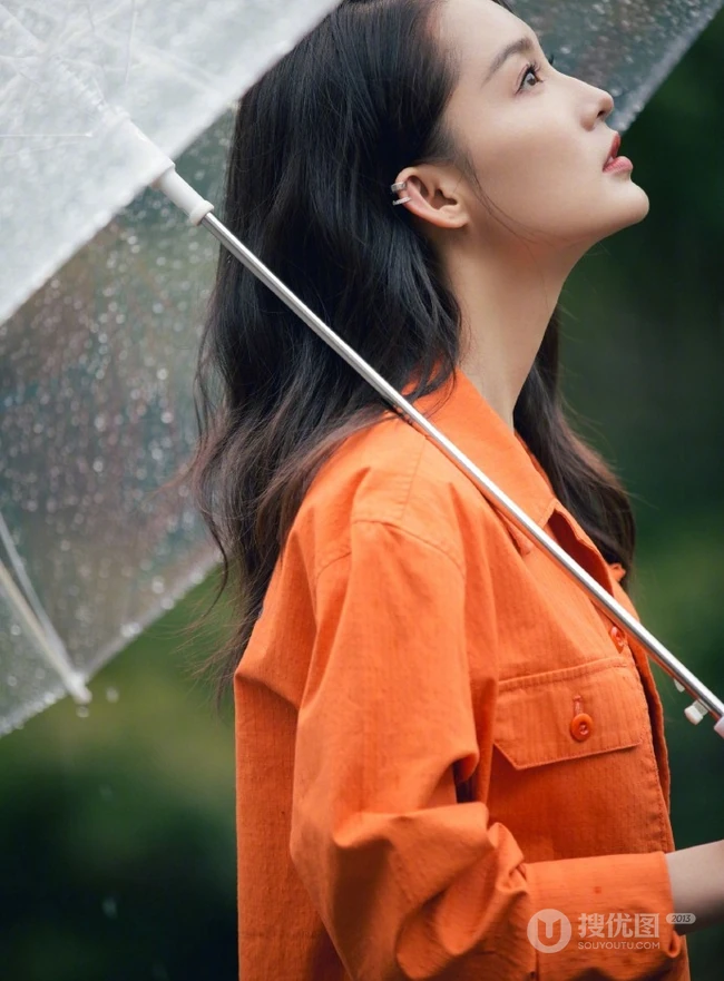李沁穿橘色外套手持雨伞现身雨天户外慵懒随性写真图片