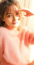 高扎马尾的浅粉少女，着粉色羊毛衣搭短裙室内享受阳光写真