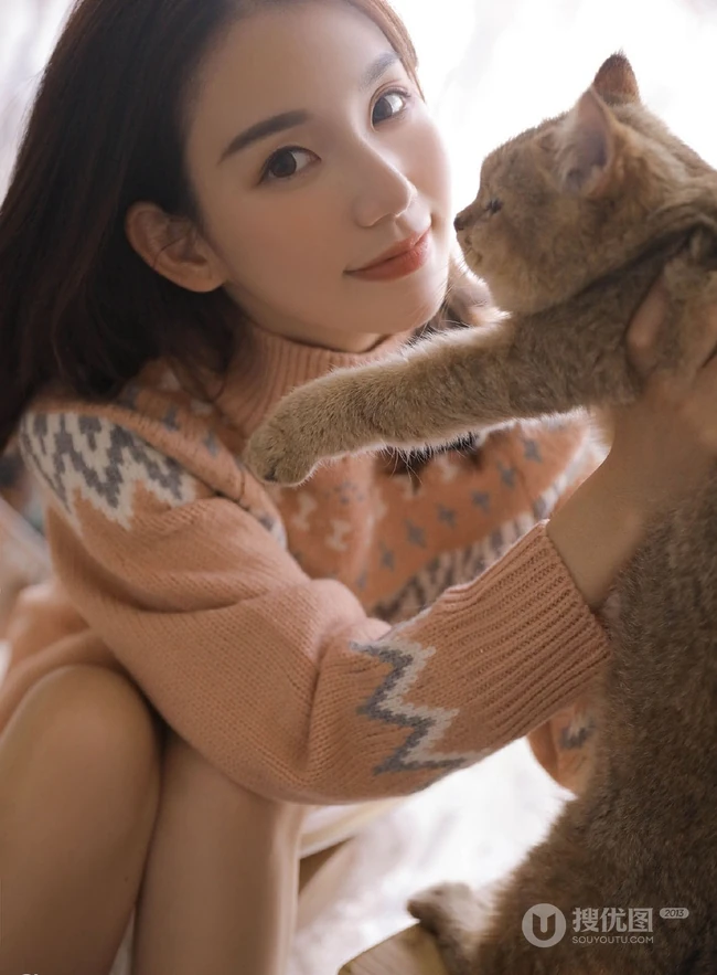 爱逗猫的白皙线条感少女，穿着毛衣短裤气质室内写真图片