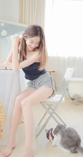 一台相机，一只猫，背心短裤可爱少女的唯美温馨室内图片