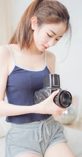 一台相机，一只猫，背心短裤可爱少女的唯美温馨室内图片