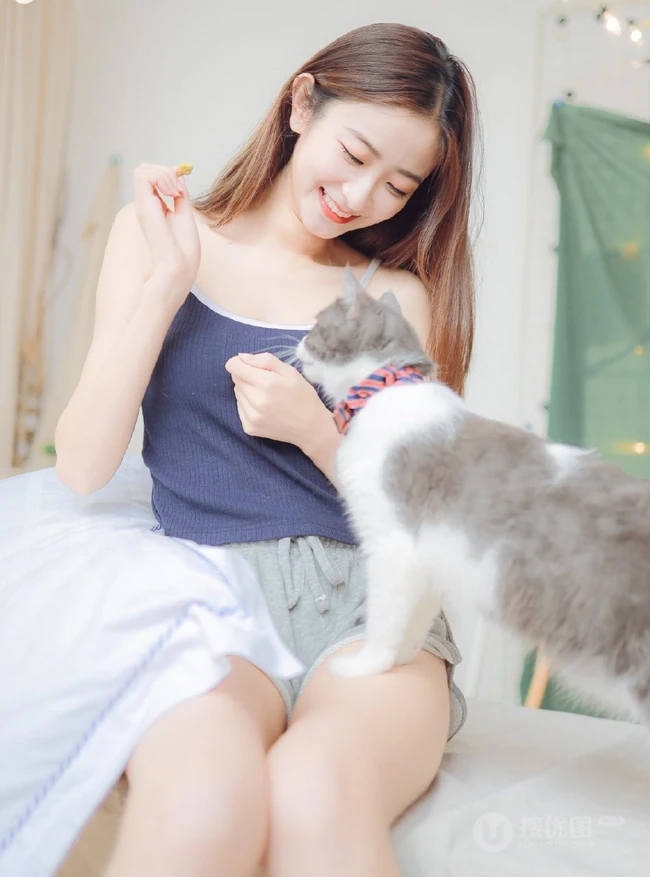 一台相机，一只猫，背心短裤可爱少女的唯美温馨室内图片