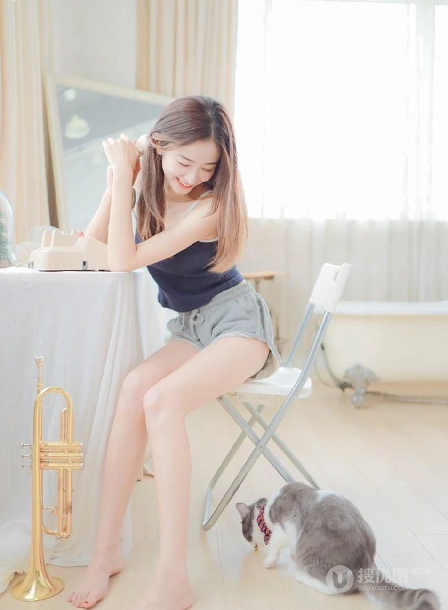 一台相机，一只猫，背心短裤可爱少女的唯美温馨室内图片