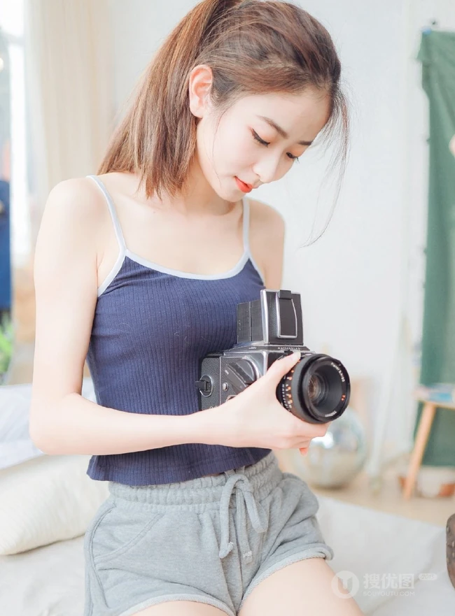 一台相机，一只猫，背心短裤可爱少女的唯美温馨室内图片