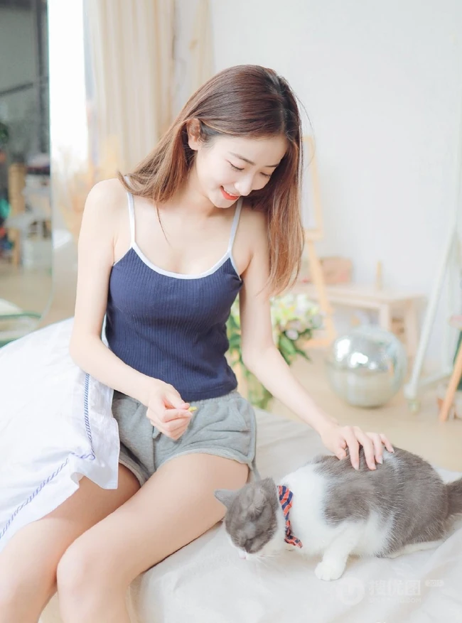 一台相机，一只猫，背心短裤可爱少女的唯美温馨室内图片