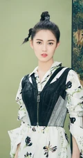 陈钰琪身穿现代感的服饰与古典背景交融，独特羊角辫造型极具个性