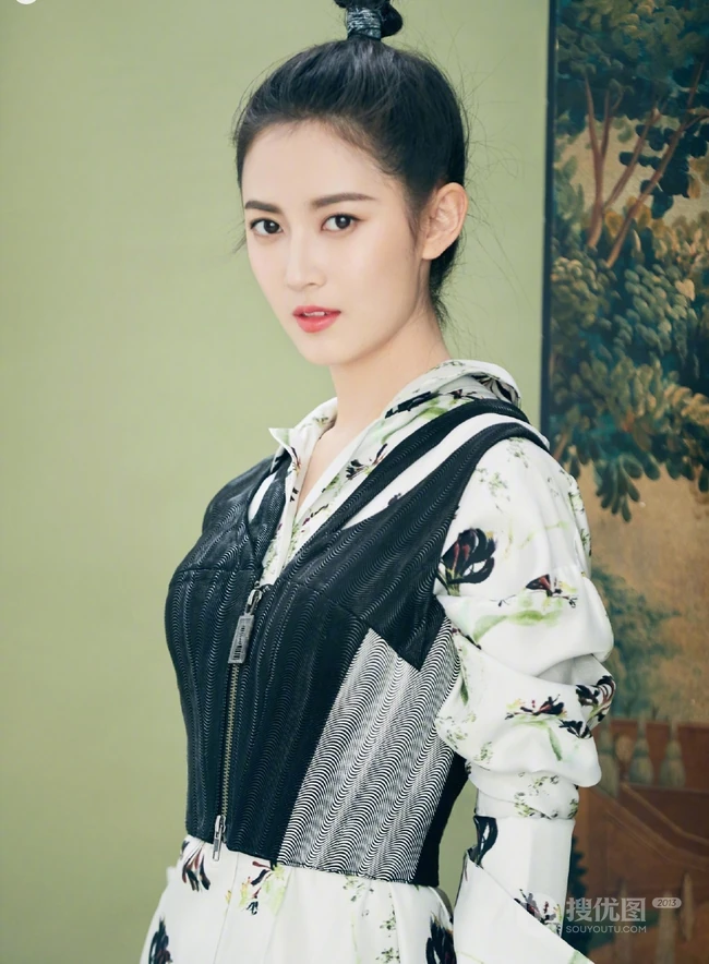 陈钰琪身穿现代感的服饰与古典背景交融，独特羊角辫造型极具个性