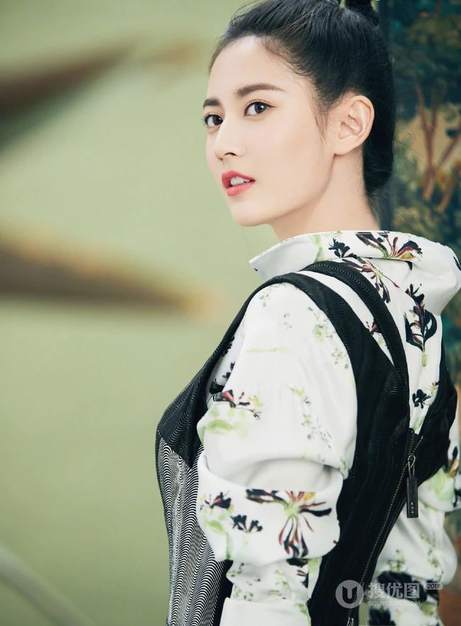 陈钰琪身穿现代感的服饰与古典背景交融，独特羊角辫造型极具个性