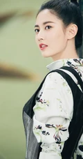 陈钰琪身穿现代感的服饰与古典背景交融，独特羊角辫造型极具个性