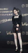 冯提莫黑衣短裙丸子头活动写真照，身材娇小线条感白皙