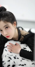 冯提莫黑衣短裙丸子头活动写真照，身材娇小线条感白皙