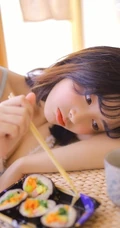 日系短发家居服少女居家吃寿司发呆浅笑动人写真图片