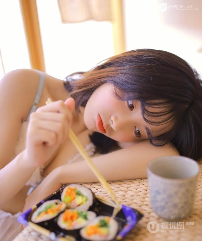 日系短发家居服少女居家吃寿司发呆浅笑动人写真图片