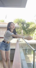 吴宣仪晒居家阳台清凉美照，T恤扎腰搭配超短牛仔裤，神情慵懒