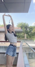 吴宣仪晒居家阳台清凉美照，T恤扎腰搭配超短牛仔裤，神情慵懒