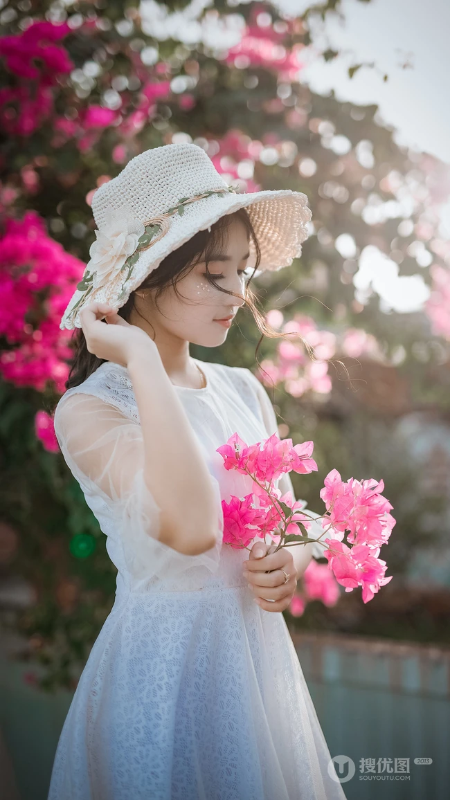 手拿鲜花带帽子的清纯美女高清手机壁纸