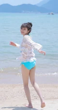 海边泳装女生，有点小微胖可爱丸子头泳装女生海边玩耍写真