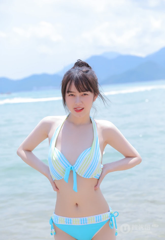 海边泳装女生，有点小微胖可爱丸子头泳装女生海边玩耍写真